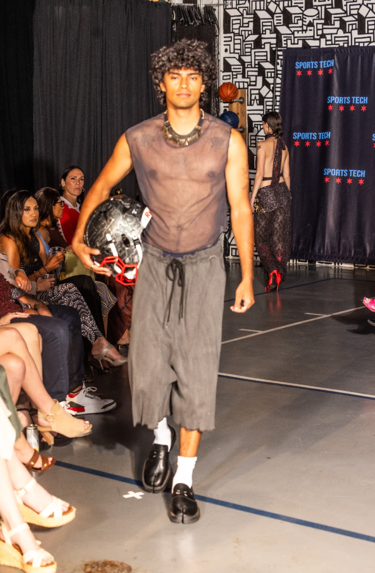 Model carrying a football helmet at The Tunnel Walk