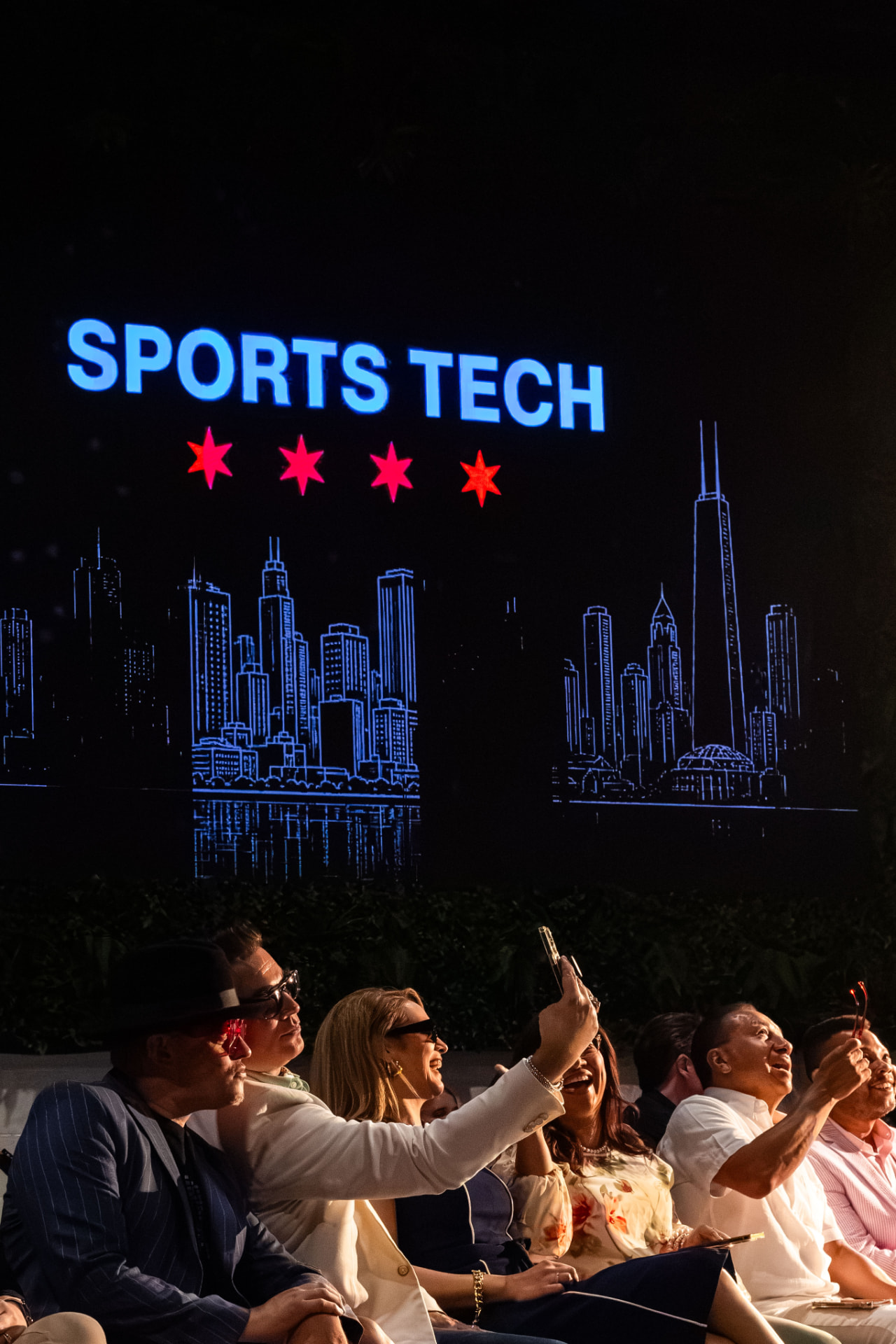 Guests taking photos in front of the event screen